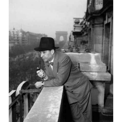El escritor francés Georges Simenon (1903-1989) fumando pipa en un balcón del Hotel Claridge